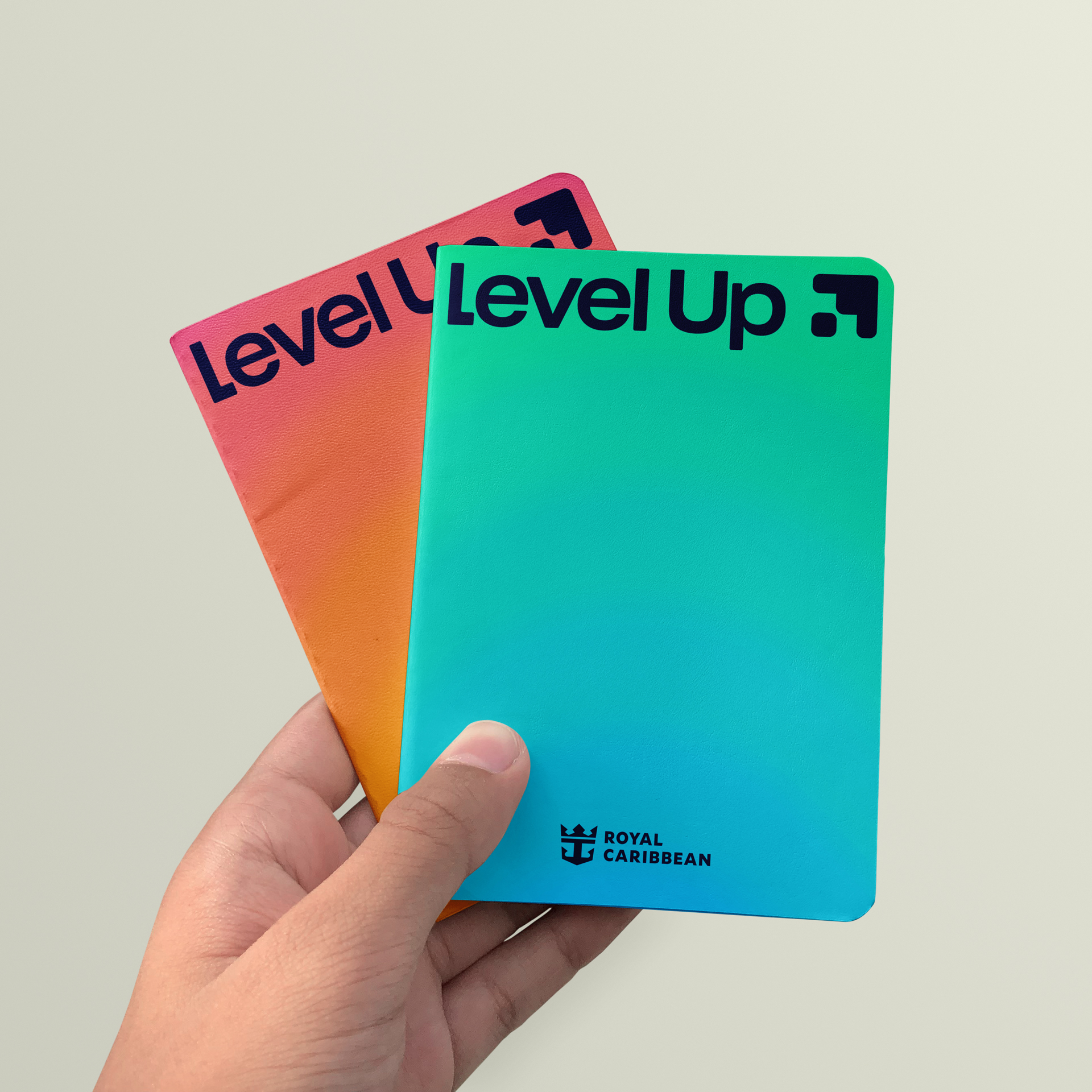 A mockup of someone holding some Level Up branded notebooks