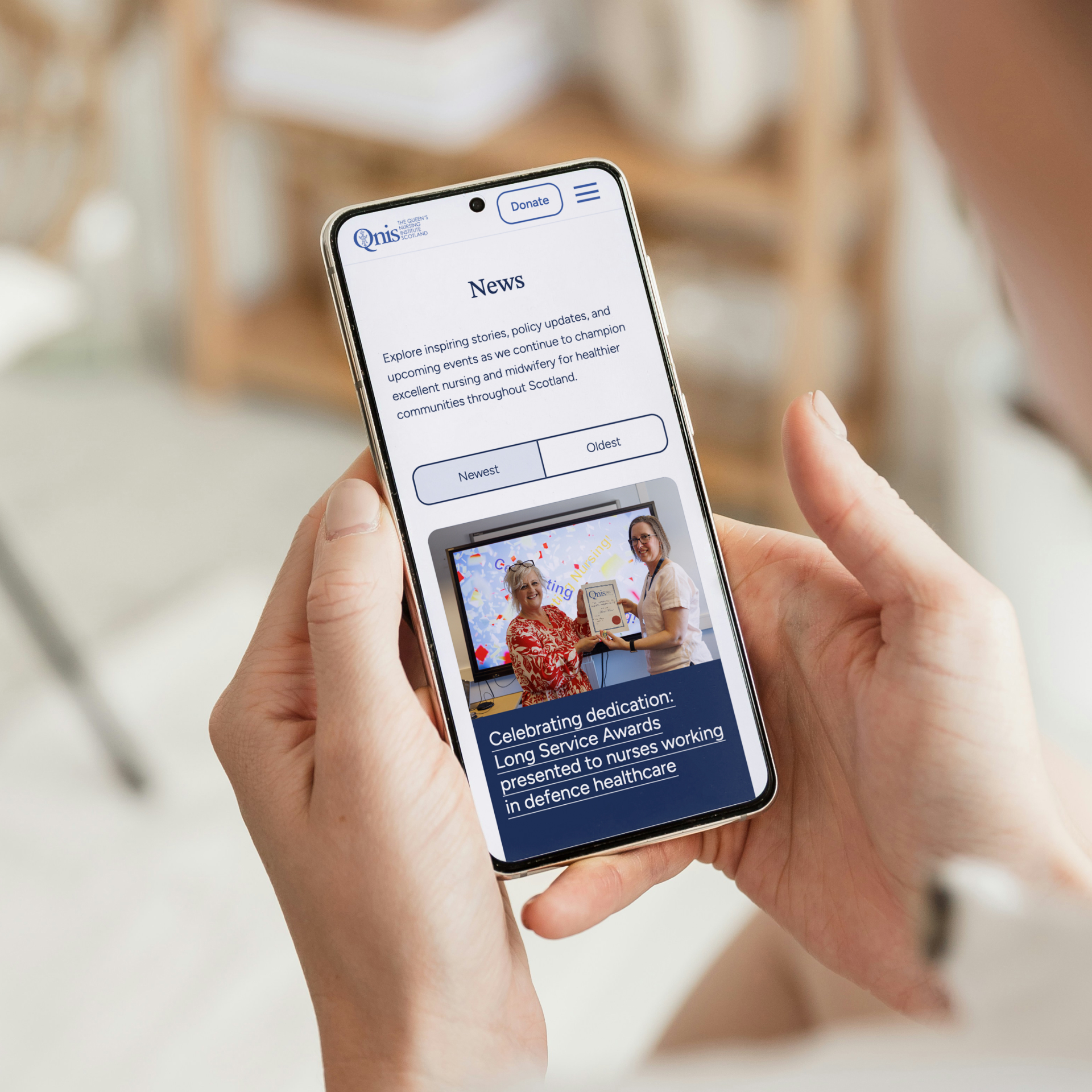 An over the shoulder shot of a person looking at the QNIS website on their mobile